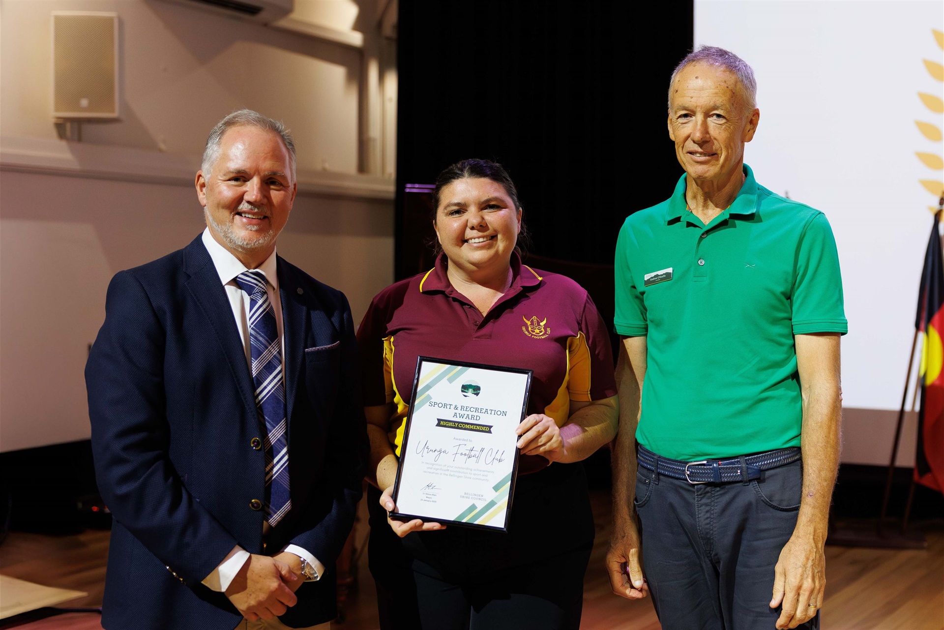 Mayor Cr. Steve Allan, Jess Snow accepting on behalf of Urunga Football Club, Cr. Andrew O'Keeffe