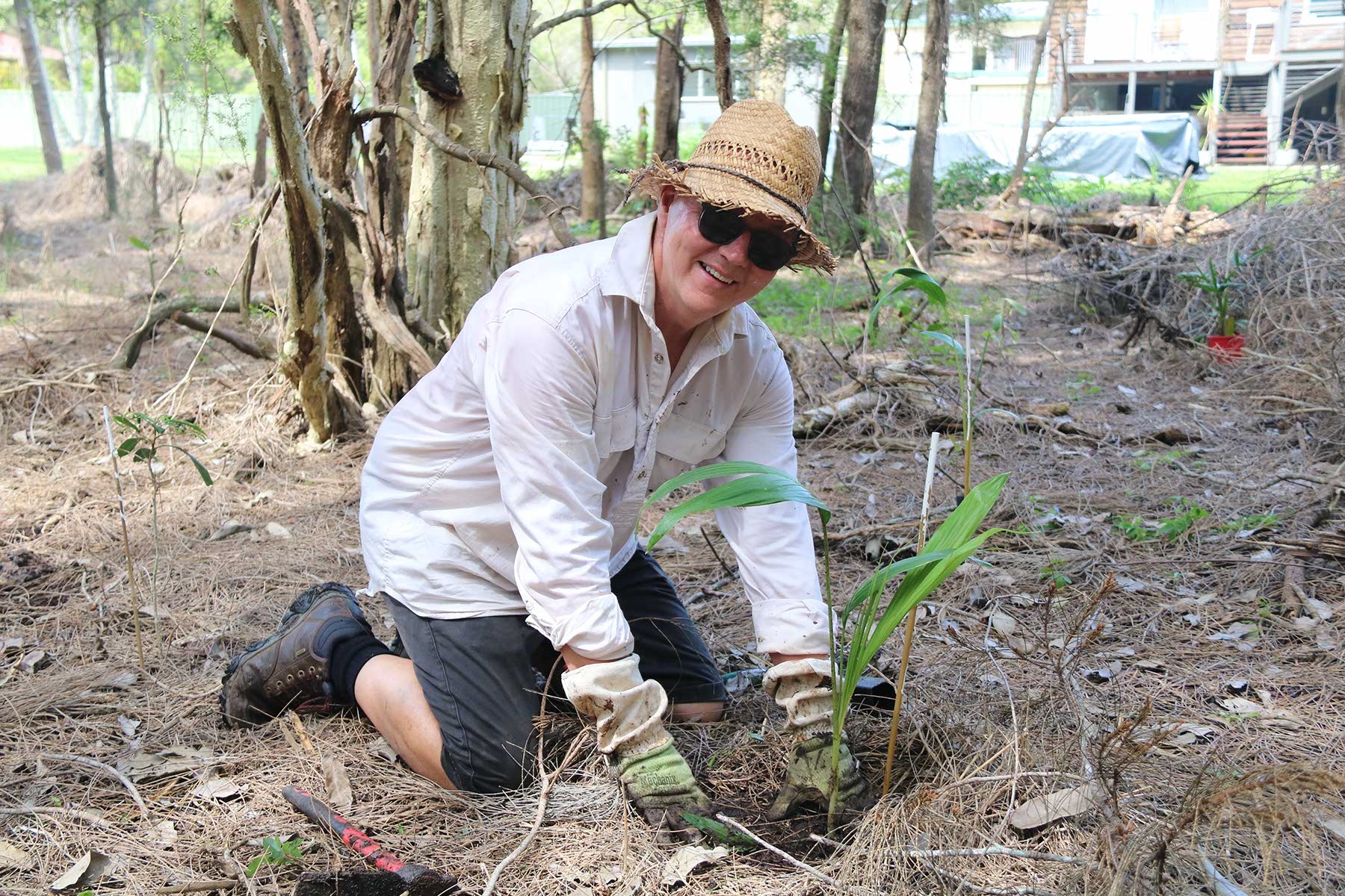 Mayor Cr,. Steve Allan, planting alongside volunteers at the important bushland site near Lions Park, Urunga